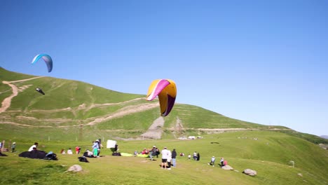 People-Setting-Up-Paragliding-Gear-On-Hilltop-In-Kazbegi,-Georgia