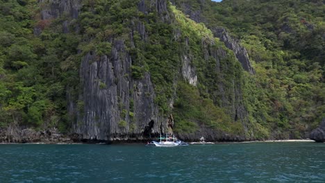 A-fisherman-sails-towards-an-island-on-a-sunny-day-at-El-Nido-Palawan,-Philippines