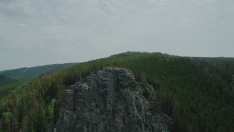 Circling-aerial-of-steep-cliff-in-the-mountains-of-Wyoming-with-an-eagle-soaring-beneath-the-cliff