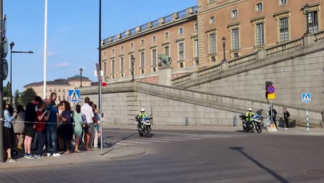 Policía-En-Motocicletas-Por-El-Palacio-Real-Sueco-En-El-Día-Nacional,-Vista-Amplia