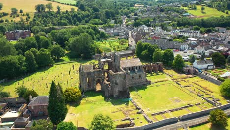 Luftaufnahme-Der-Erkundung-Der-Ruinen-Der-Melrose-Abbey,-Einem-Berühmten-Wahrzeichen-In-Einer-Kleinen-Stadt-An-Der-Schottischen-Grenze