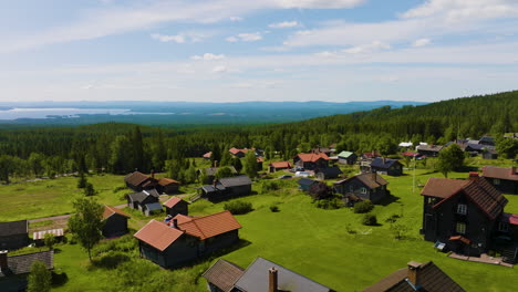 Drone-ascending-and-panning-left-over-house-roofs-in-small-Swedish-village