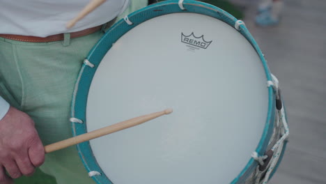 Drummer's-hand-playing-a-snare-drum-with-wooden-sticks-in-an-outdoor-performance