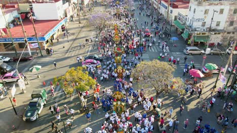 Tilt-up-aerial-view-of-a-group-of-pilgrims-going-to-the-Guadalupe-Basilica-in-CDMX,-Mexico-on-a-sunny-day,-slow-motion