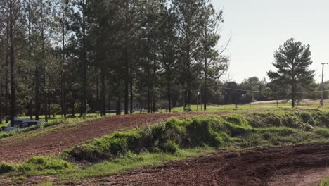 Motocross-competition-winner-jumps-over-hill-on-muddy-dirt-track