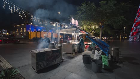 Roasted-chestnut-vendor-selling-Madeira-delicacy-from-stand-on-street-at-night