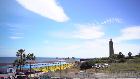 Estepona-seaside-with-tall-stone-lighthouse,-panning-view