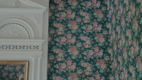 Close-up-of-a-vintage-floral-wallpaper-with-a-white-decorative-molding,-showcasing-elegant-interior-design-elements