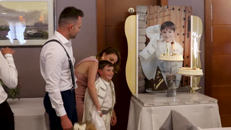 mother-and-father-present-a-cake-and-a-portrait-picture-to-their-son