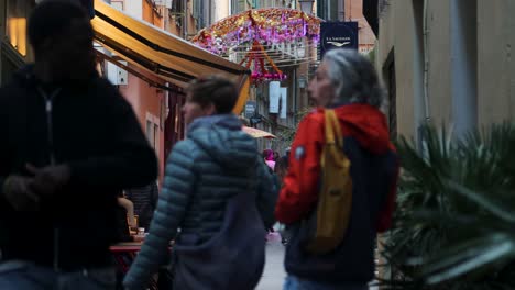 Colorful-street-scene-in-Old-Town-of-Nice,-France-with-people-walking-and-enjoying-the-evening