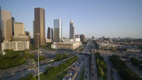 Wide-angle-pulling-away-shot-of-downtown-Houston-and-cars-on-I-45-freeway