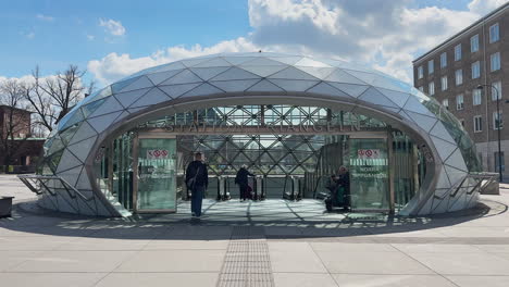 People-enter-the-city-tunnel-at-Triangeln-Station-in-Malmö,-near-the-Triangle-Mall,-passing-through-the-distinctive-dome-entrance