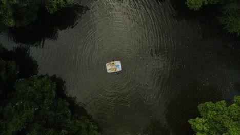 Aerial-top-down-of-two-people-paddling-with-boat-on-tropical-lagoon-of-Venezuela