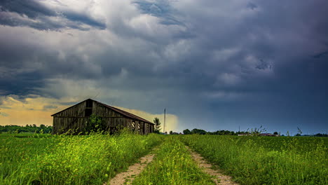 Ein-Alter-Verfallener-Holzschuppen-Unter-Gewitterwolken-Auf-Einer-Grünen-Wiese