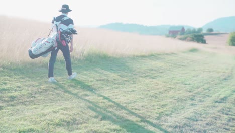 Golfista-En-El-Campo-De-Golf-Llevando-Una-Bolsa-Con-Palos-En-Un-Entorno-Idílico