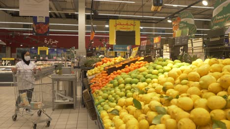 Kardangelenk-Näherungsaufnahme-Einer-Frau-Mit-Gesichtsmaske,-Die-Auf-Dem-Markt-Ponkan-Auswählt