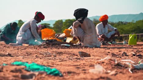 Eine-Gruppe-Von-Stammesangehörigen-Sitzt-Zusammen-Und-Macht-Essen-In-Pushkar,-Rajasthan,-Indien