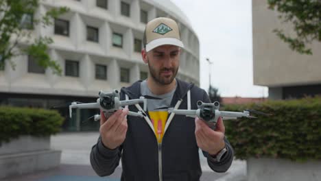 Caucasian-man-holds-two-drones-and-looks-at-an-compares-the-quadcopters