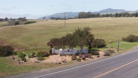 Low-push-in-aerial-shot-of-the-entrance-to-Hearst-Castle-along-Highway-1-in-San-Simeon,-California