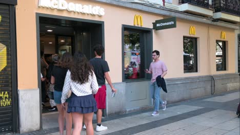 Los-Clientes-Entran-En-La-Cadena-De-Restaurantes-De-Hamburguesas-De-Comida-Rápida-Multinacional-Americana,-McDonald&#39;s,-En-Madrid,-España.