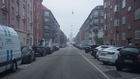 Street-in-Copenhagen-Denmark,-with-a-church-in-the-end-on-a-overcast-cold-winter-day