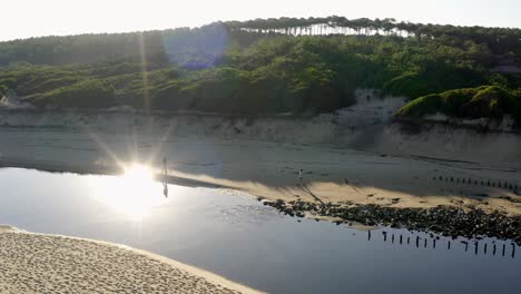 Shot-of-a-drone-of-a-couple-wandering-along-a-water-court