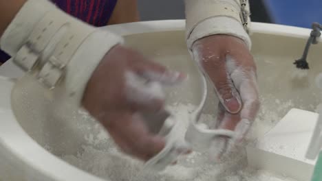 Asian-gymnast-chalks-up-her-hands-before-a-gymnastics-workout