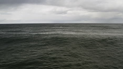 Seaside-View-Of-Dark-Calm-Ocean-With-Horizon-and-Cloudy-Gray-Sky,-Neskowin-Oregon-Coast-USA