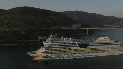 AIDANova-Cruise-Ship-Sailing-Out-Of-Dubrovnik,-Croatia-Port-On-Scenic-European-Cruise,-Aerial-5K-Drone