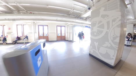 Walking-Towards-The-Exit-Door-Of-Amsterdam-Central-Railway-Station-In-Amsterdam,-Netherlands---fisheye-view,-wide-shot