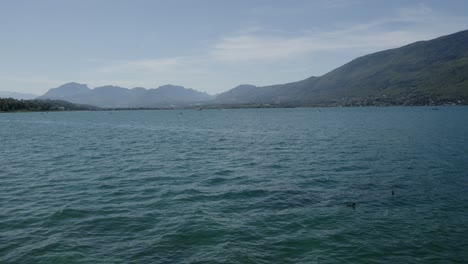 Navegación-En-Cámara-Lenta-En-El-Lago-Azul-Debajo-De-La-Luz-Del-Día-De-Fondo-De-Montaña-Alpina