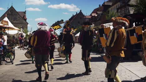 Vídeo-Cinematográfico-De-Un-Pueblo-Marchando-Y-Ondeando-Las-Banderas-De-Neuburg-A-Der-Donau-Y-Palatinado-Neuburg-Durante-El-Festival-Wallenstein-En-Altdorf,-Baviera