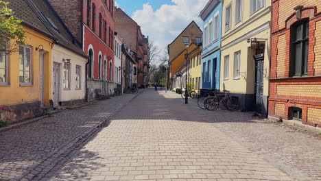 Moving-forward-in-Gamla-Vaster,-Malmo,-picturesque-neighbourhood-with-colourful-houses-and-cobblestone-streets