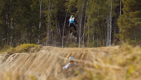 Motocross-riders-jump-on-a-dirt-track-one-after-another-in-slow-motion