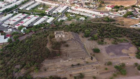 Shot-with-a-drone-over-the-El-Cerrito-Archaeological-Zone,-showing-how-history-meets-the-present