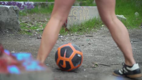 Closeup-of-soccer-girl-dribbling-ball-around-rocks,-preparing-to-kick,-slow-motion-tracking