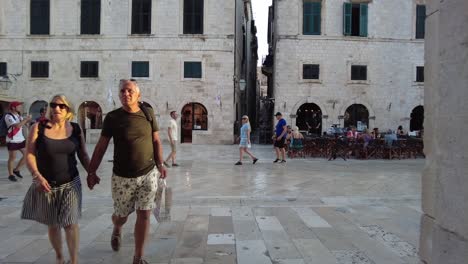 Paseando-Por-La-Zona-Peatonal-Del-Casco-Antiguo-De-Dubrovnik-Por-La-Noche,-Disfrutando-Del-Encantador-Ambiente-Y-El-Encanto-Histórico.