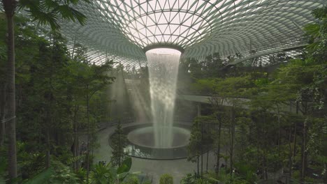 Light-leaks-through-the-indoor-forest-and-world's-tallest-indoor-waterfall-in-Jewel-Changi-Airport-in-Singapore-4k