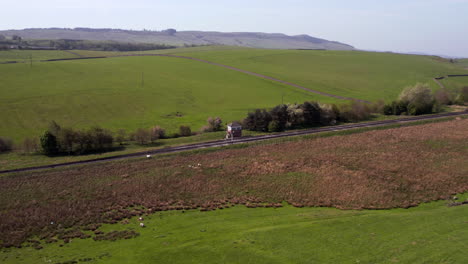 Toma-Aérea-Acercándose-A-Una-Caja-De-Señales-Solitaria-En-Una-Línea-De-Tren-Rural-En-Yorkshire-Del-Norte,-Inglaterra,-En-Un-Día-Soleado-De-Verano