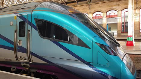 Modern-Transpennine-Express-train-stopped-at-platform-at-railway-station-in-UK