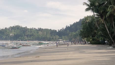 Port-Barton-Beach-with-people-in-early-morning-sunlight-in-Palawan,-The-Philippines-in-ultra-slow-motion