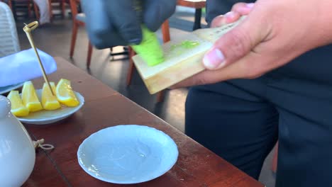 fresh-wasabi-rhizome-being-grated-on-a-shark-skin-grater-in-a-restaurant,-real-wasabi-paste