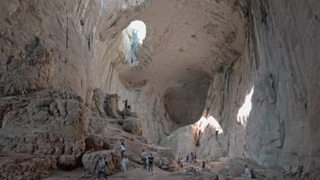 Tourists-explore-cavernous-chamber-Eyes-of-God-karst-cave-Prohodna