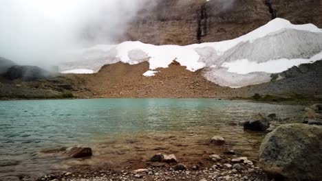 Zeitraffer-Eines-Bergsees-Namens-Tarn-In-Der-Nähe-Des-Panhandle-Gap-Im-Mount-Rainier-Nationalpark-Mit-Wolken,-Die-Sich-Schnell-über-Den-Pass-Bewegen