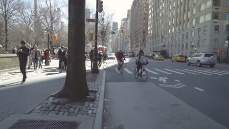 Group-of-people-waits-at-a-crosswalk-in-Manhattan-while-several-people-go-by-on-bicycles