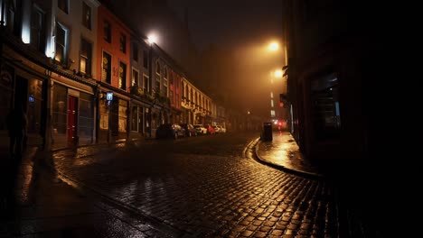 Girl-walking-on-empty-Victoria-Street-in-Edinburgh-on-a-quiet-foggy-night