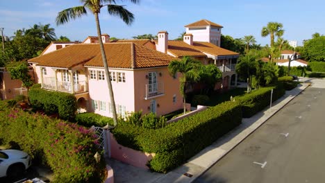 Aerial-view-rising-towards-a-large-mansion,-during-sunrise,-in-Palm-Beach,-Miami,-Florida,-USA---tilt-down,-drone-shot