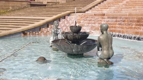 Close-up-of-statues-of-two-people-in-water-fountain-The-River-Floozie-in-the-Jacuzzi-in-Birmingham,-the-Midlands,-England-UK