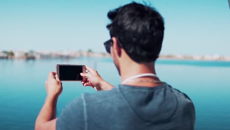 Boy-Taking-picture-with-his-phone-on-a-ferry-in-his-way-to-Djerba