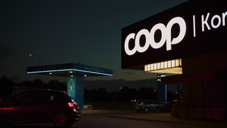 Tráfico-De-Vehículos-Por-La-Noche-Frente-A-La-Tienda-Coop-Y-A-La-Gasolinera-Alexela